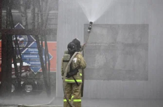 пожарные в боевой одежде работают со стволом на учениях