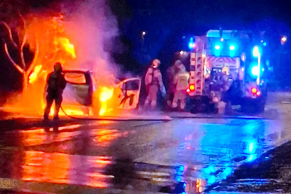 пожарные тушат горящий автомобиль ночью